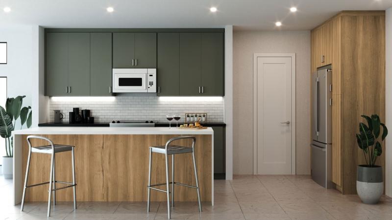 Frameless slab cabinetry in green with a woodgrain island and tall pantry