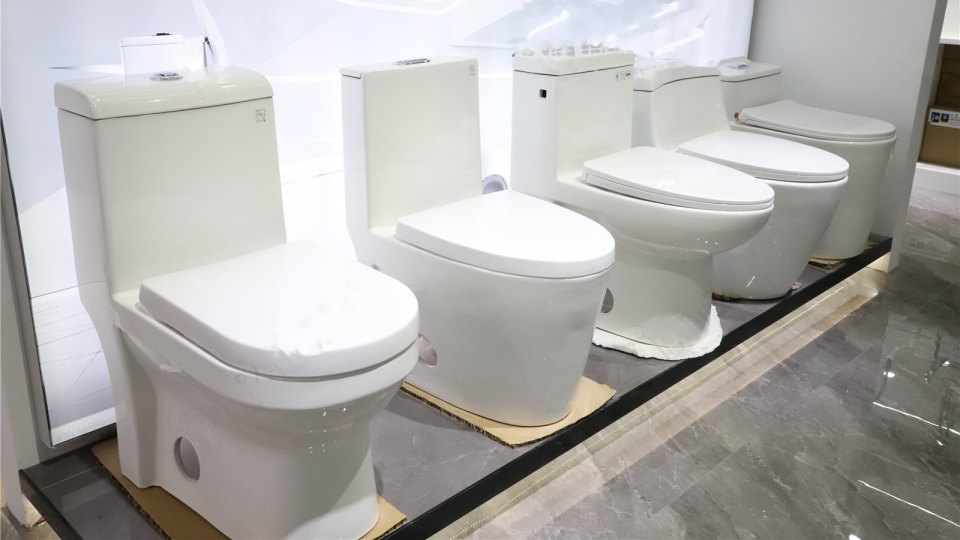 Row of white one-piece toilets on display
